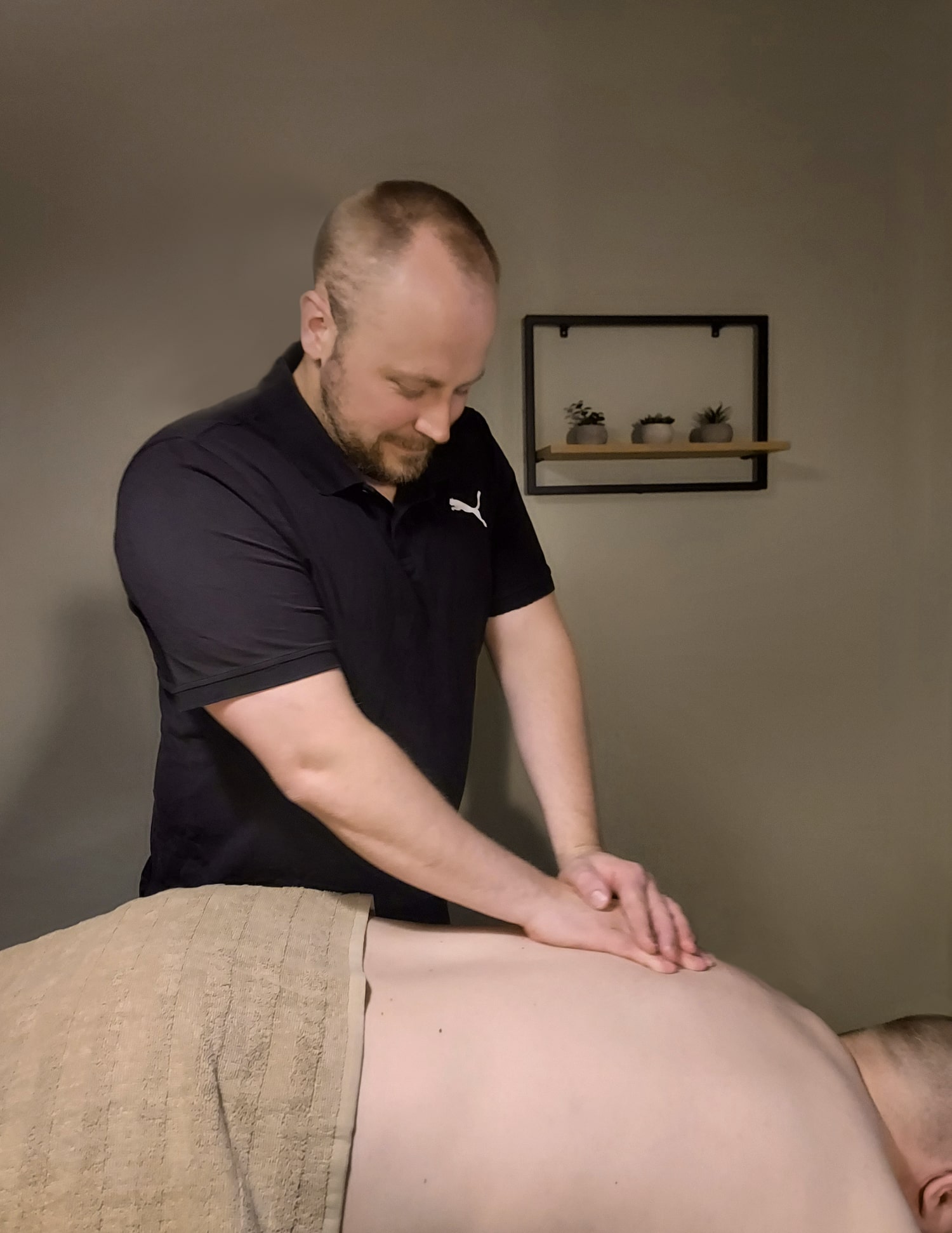 Hieronta-Gylden-hieroja-Iiro-Muurame-Jyvaskyla-Korpilahti-Saynatsalo Hieroja hieroo asiakkaan selkaa.